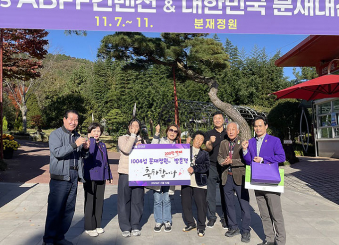 신안군 관계자들이 신안 분재정원 200만번째 방문객과 기념사진을 찍고 있다./사진제공=신안군