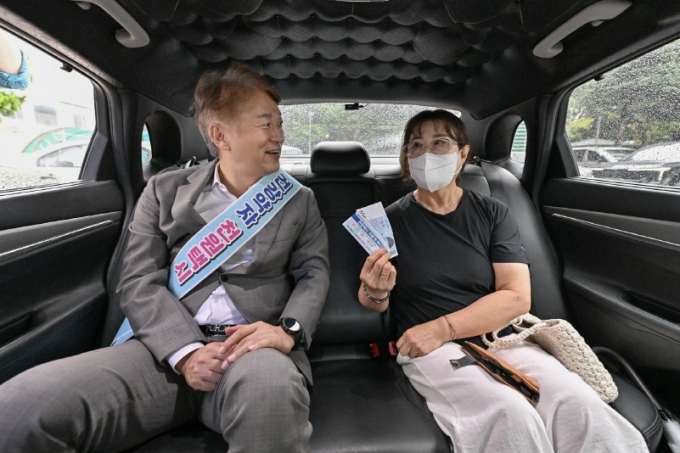 김이강 광주광역시 서구청장(왼쪽)이 지난 9월9일 천원택시 운영 현장을 찾아 이용객의 의견을 듣고 있다./사진제공=광주 서구