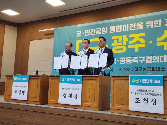 12일 수원특례시, 대구광역시, 광주광역시 시민단체가 정부를 상대로 군공항 및 민간공항 통합이전 사업의 조속한 추진을 촉구하는 공동협약서를 들고 사진촬영을 하고 있다. /사진제공=수원군공항이전 및 경기통합국제공항추진시민협의회