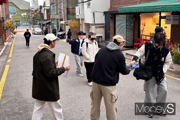 사진은 초코바를 나눠주는 황씨와 왈리씨의 모습. /사진=김다솜 기자