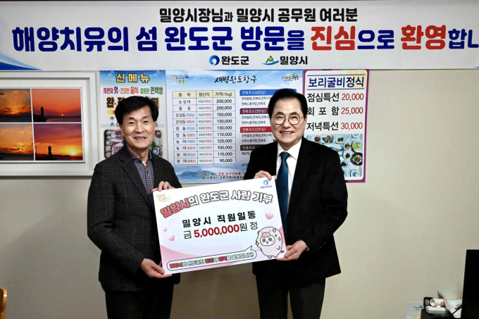 안병구 밀양시장(왼쪽)이 공무원들이 자발적으로 모금한 고향사랑기부금 500만원을 우호협력도시 전남 완도군에 전달하고 있다./사진=밀양시