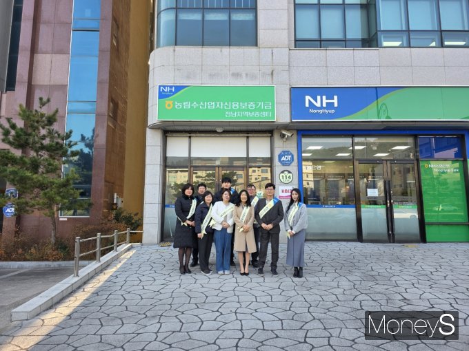 농림수산업자신용보증기금 전남지역보증센터 직원들이 새롭게 이전한 남악 신도시 사무실 앞에서 기념촬영을 하고 있다/사진=농협전남본부 제공.