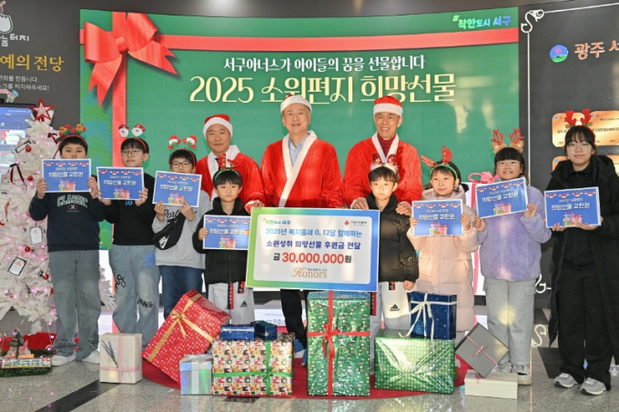 김이강 광주시 서구청장(뒤줄 가운데)이 3일 서구아너스로부터 받은 '소원성취 희망선물'을 지역 아동청소년에게 전달하고 기념촬영 하고 있다./사진=광주 서구 