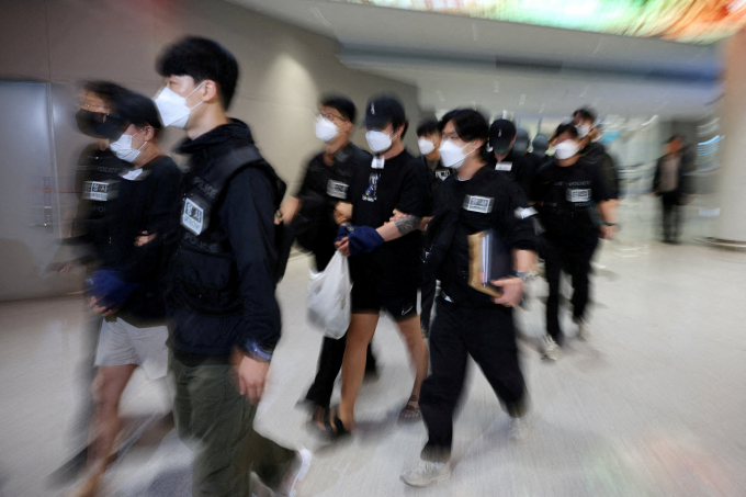 정부가 한국인 대상 취업사기·납치·감금 사태에 대응하기 위해 캄보디아 프놈펜, 시엠립 등 일부 지역 여행경보를 하향했다. 사진은 지난 10월18일 캄보디아에서 온라인 사기에 연르된 한국인 추방자들을 경찰이 연행한 모습. /사진=로이터