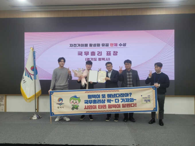 퍙택시 관계자들이 '자전거 이용 활성화 유공' 국무총리상을 받은 뒤 기념촬영을 짝고 있다. /사진제공=평택시