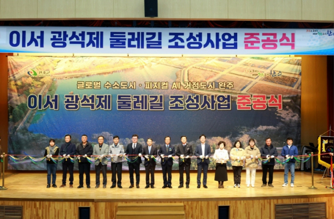유희태 완주군수(왼쪽에서 여덟 번째)와  도·군의원, 화산·경천면민 등이 경천저수지 둘레길·황톳길 준공식에 참석해 테이프 커팅을 하고 있다./사진제공=완주군
