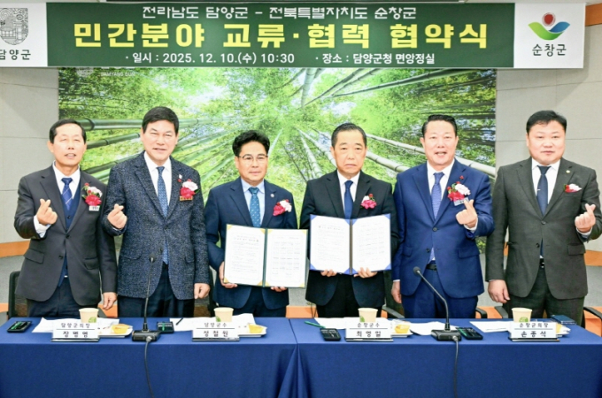 최영일 순창군수(왼쪽부터 다섯번쨰)와 정철원 담양군수(두번째)가 담양군청 면앙정실에서 '순창군-담양군 민간분야 교류 협력 협약식'을 갖고 두 지역 이장협의회장들이 협약서를 내보이며 기념촬영을 하고 있다./사진제공=순창군