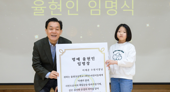 율현초등학교 일일교장이 된 이재준 수원시장(왼쪽)이 학생 대표로부터 '명예 율현인' 임명장을 받고 있다. /사진제공=수원시 