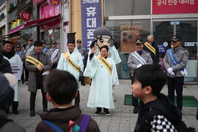 주광덕 남양주시장(가운데 줄 왼쪽서 4번째) 등 참석자들이 10일 다산한강초등학교 앞 사거리에서 정약용 캐릭터와 포돌이·포순이가 함께 참여한 민·관·경·학 합동 '등굣길 아동 안전 캠페인'을 실시하고 있다. /사진제공=남양주시 