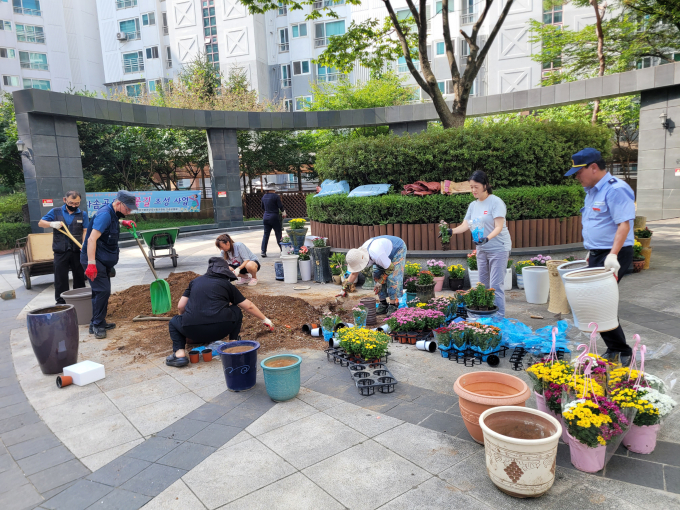 병점역 동문굿모닝힐 입주민들이 폐화분을 활용해 꽃길 만들기 활동을 하고 있다. /사진제공=화성특례시