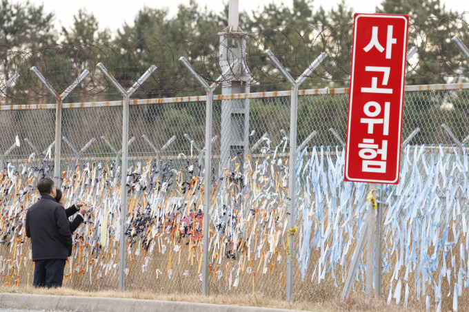 12·29 여객기 참사 1주기를 하루 앞둔 28일 전남 무안국제공항 활주로 인근에서 시민들이 179명의 희생자의 넋을 기리는 파란 리본을 부착하고 있다. /사진=뉴스1