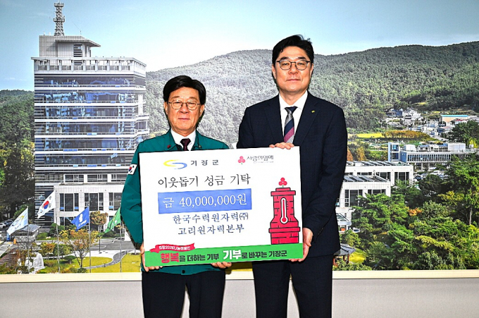 정종복 기장군수(왼쪽)가 이상욱 고리본부장으로부터 성금을 전달받고 기념촬영을 하고 있다./사진=기장군