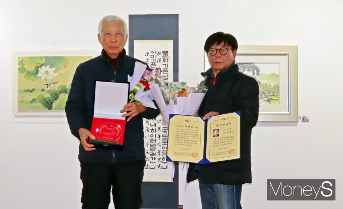 정영철 팔공문화예술협회장(오른쪽)이 대한민국 명인 인증서 서예 부문을 받은 서정호 작가(왼쪽)과 인증서를 들어보이고 있다./사진=황재윤 기자